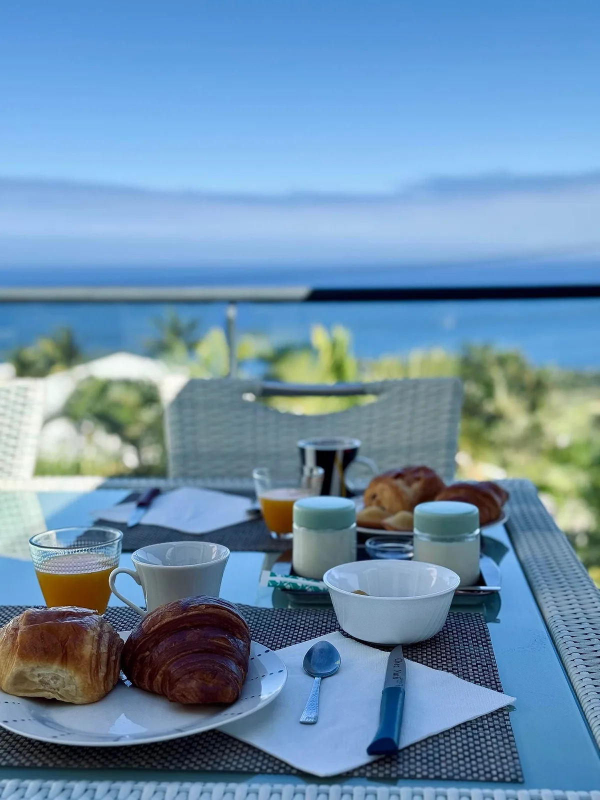 Le petit déjeuner servi sur la table de la terrasse, l'océan au loin