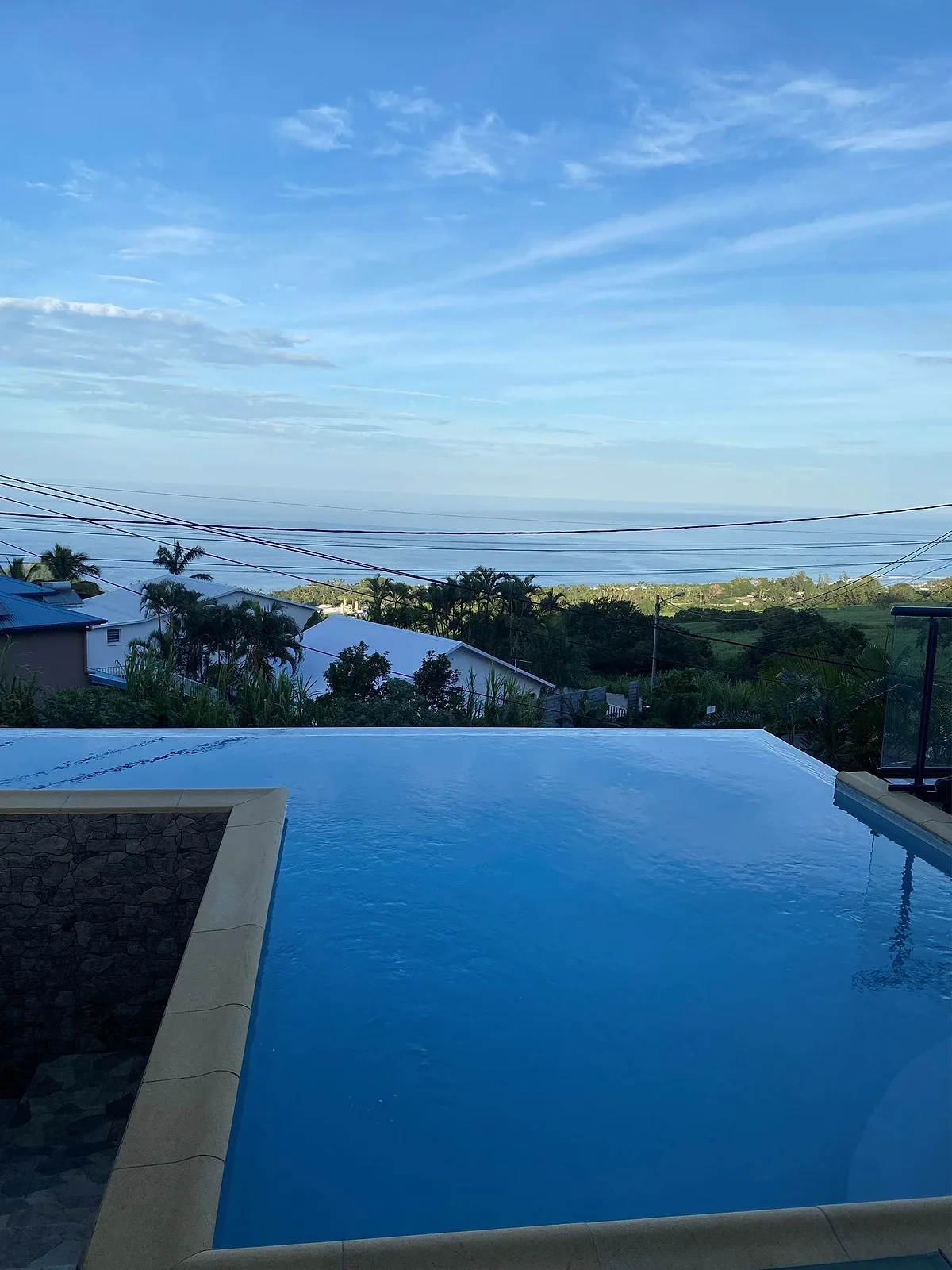 La piscine à débordement au crépuscule, la mer au loin