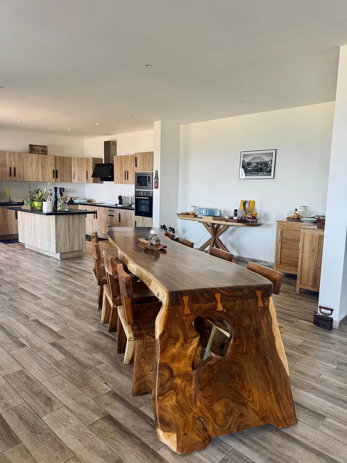 La grande pièce à vivre de la villa, sa table en bois massif et sa cuisine ouverte