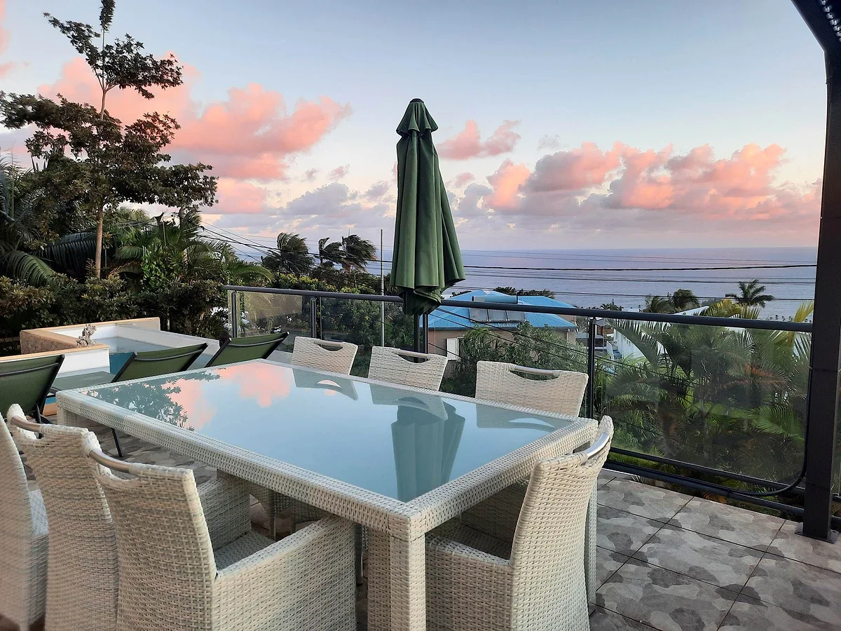 La terrasse de la villa, sa grande table et l'océan au lever du jour